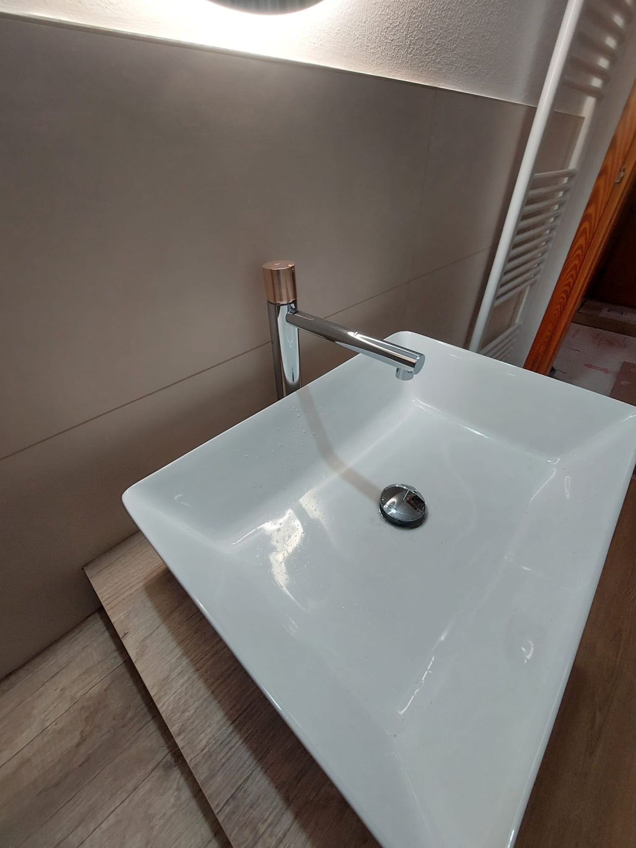 Dettaglio di lavabo bianco e rubinetteria cromata