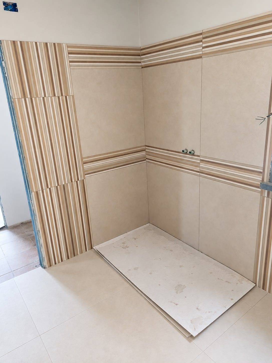 Doccia con piatto chiaro e rivestimento a doghe verticali